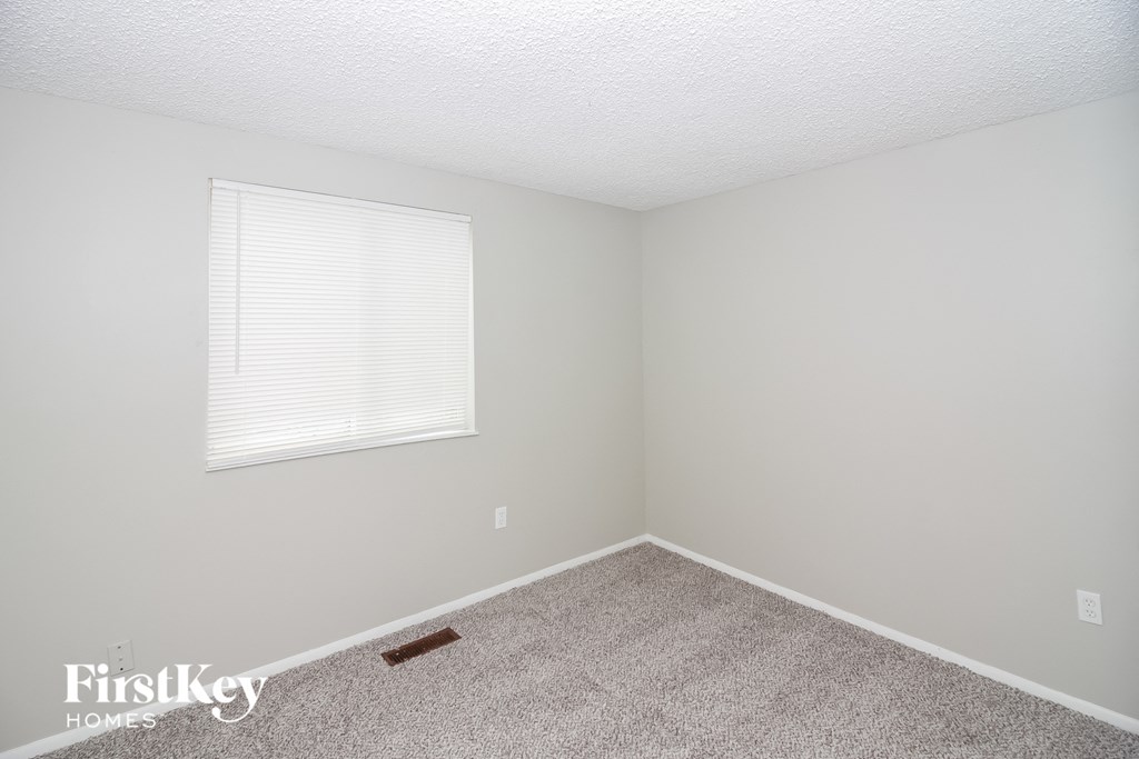 a bedroom with carpet and a window
