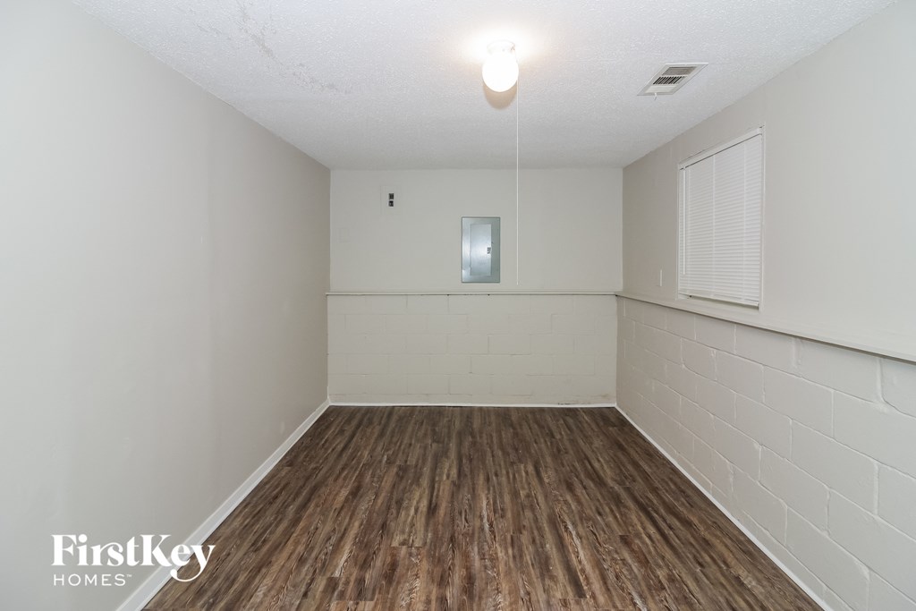an empty room with a wood floor and white walls