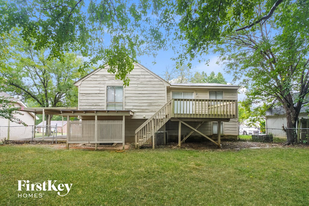 the back of a house with a deck on top of it