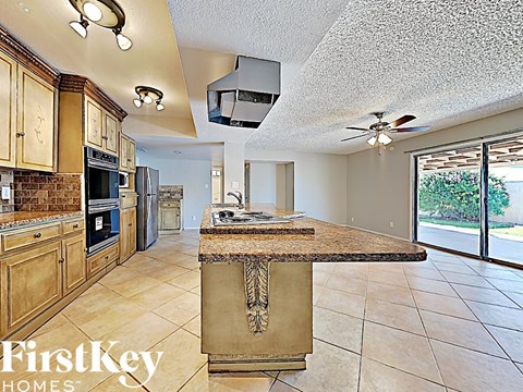 the kitchen has a large island with granite counter tops and stainless steel appliances