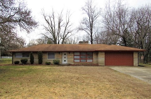 A house with a red garage door and a brown roof.
