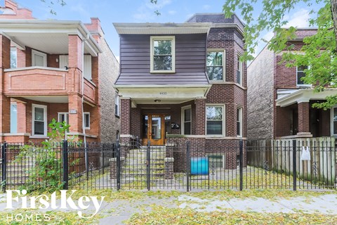 a brick house with a fence in front of it