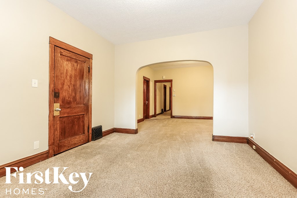 a living room with a carpeted floor and a wooden door