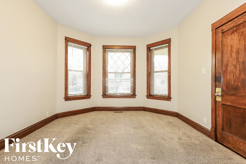 a empty room with three windows and a wooden door