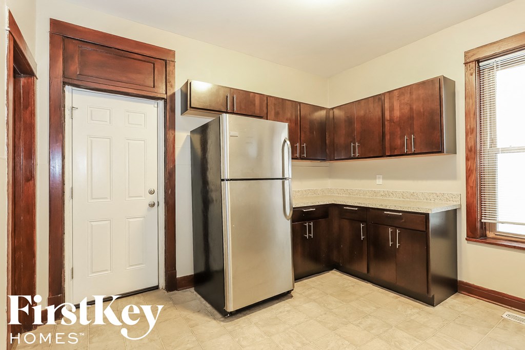 a kitchen with a stainless steel refrigerator and wooden cabinets