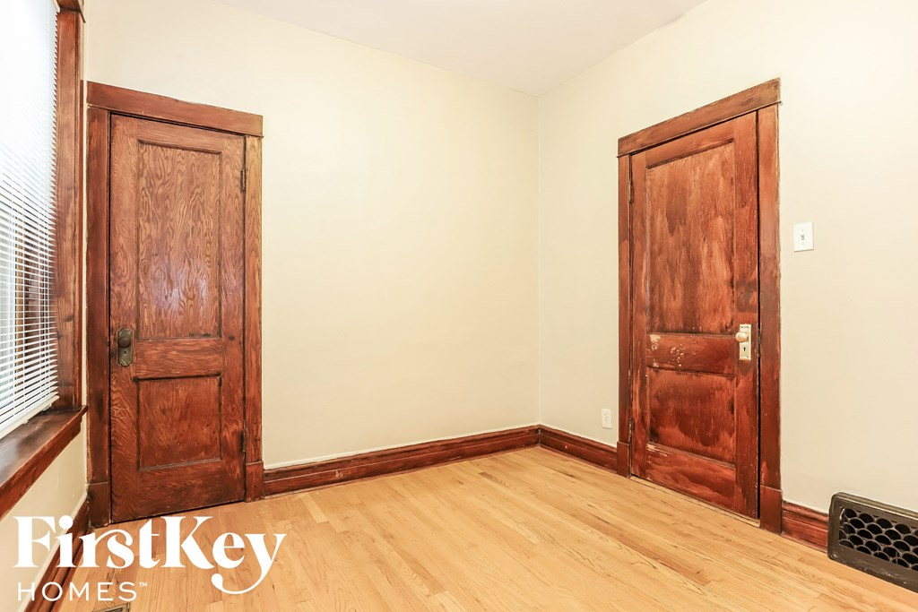 a bedroom with two wooden doors and a wood floor