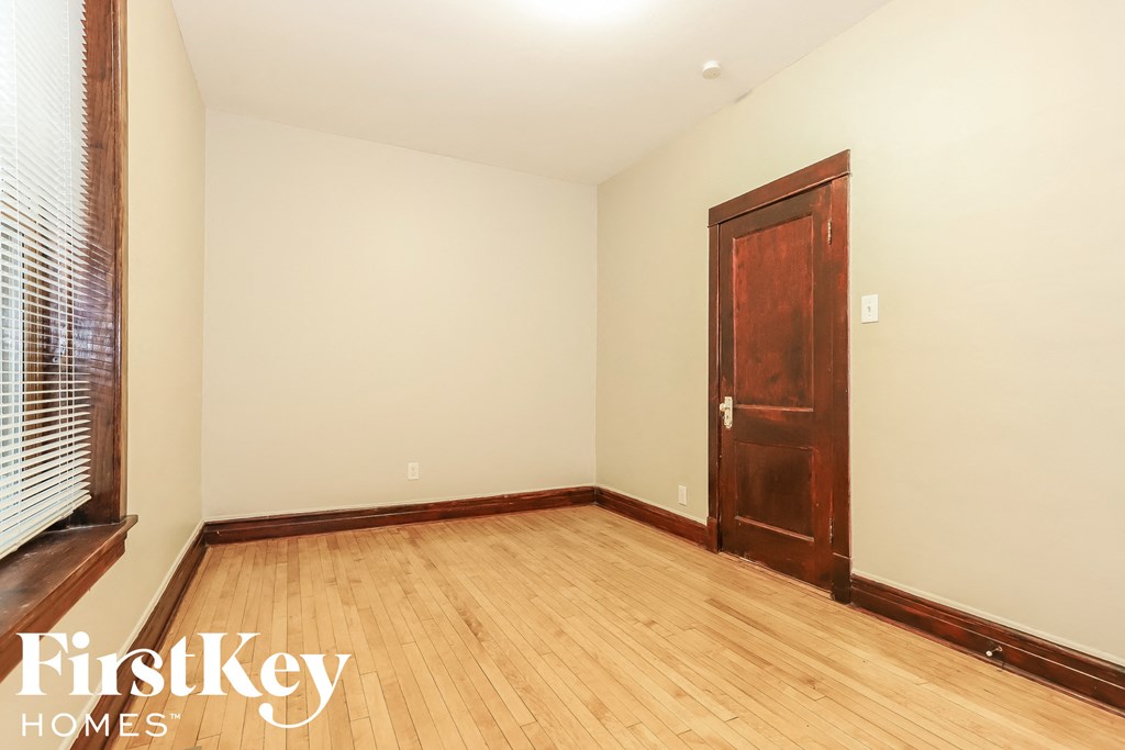 a bedroom with a wooden floor and a wooden door