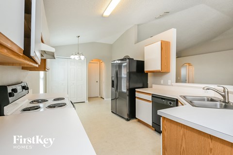 a kitchen with white counter tops and black appliances