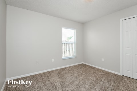 a bedroom with carpet and a window