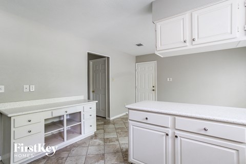 A kitchen with white cabinets and a countertop.