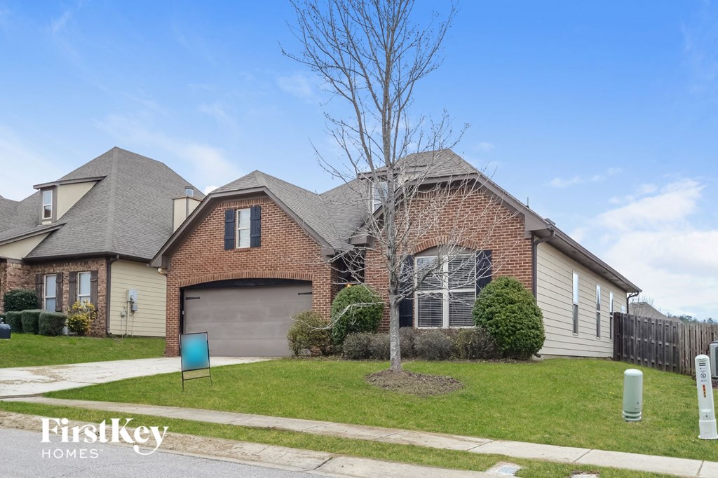 a house with a lawn and a tree in front of it