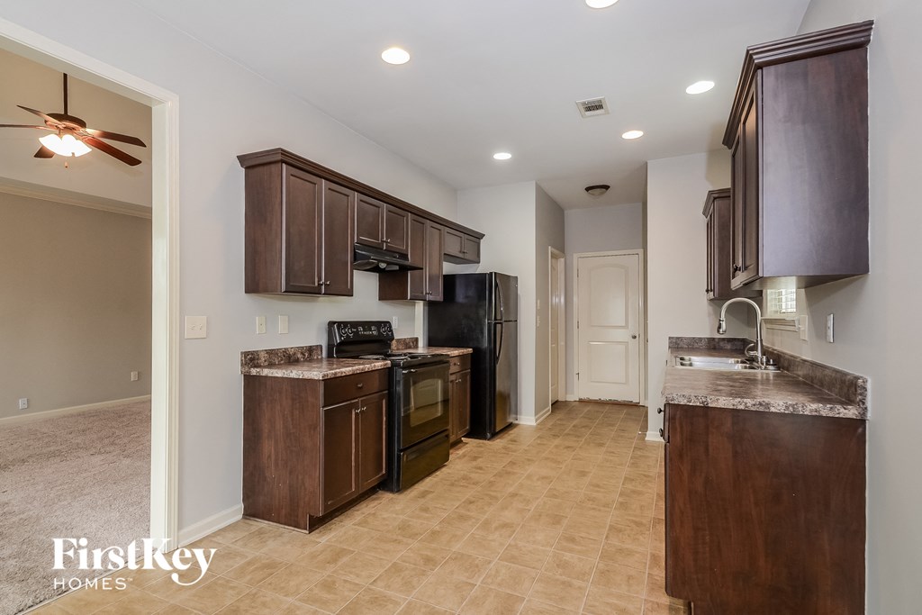 a kitchen with a stove and a refrigerator and a sink