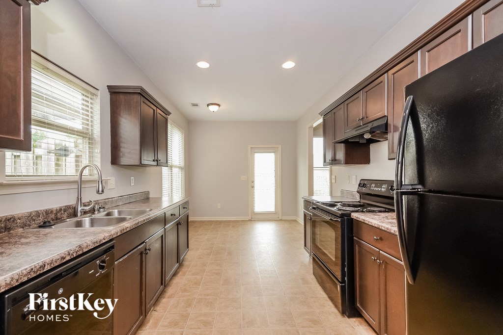 a kitchen with black appliances and wooden cabinets