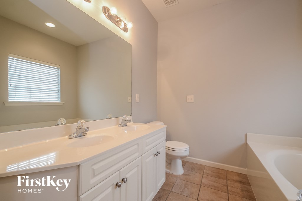 a bathroom with a large mirror and a sink and a toilet