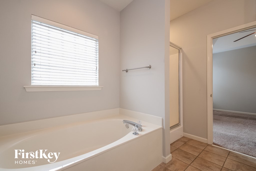 a bathroom with a tub and a window and a mirror