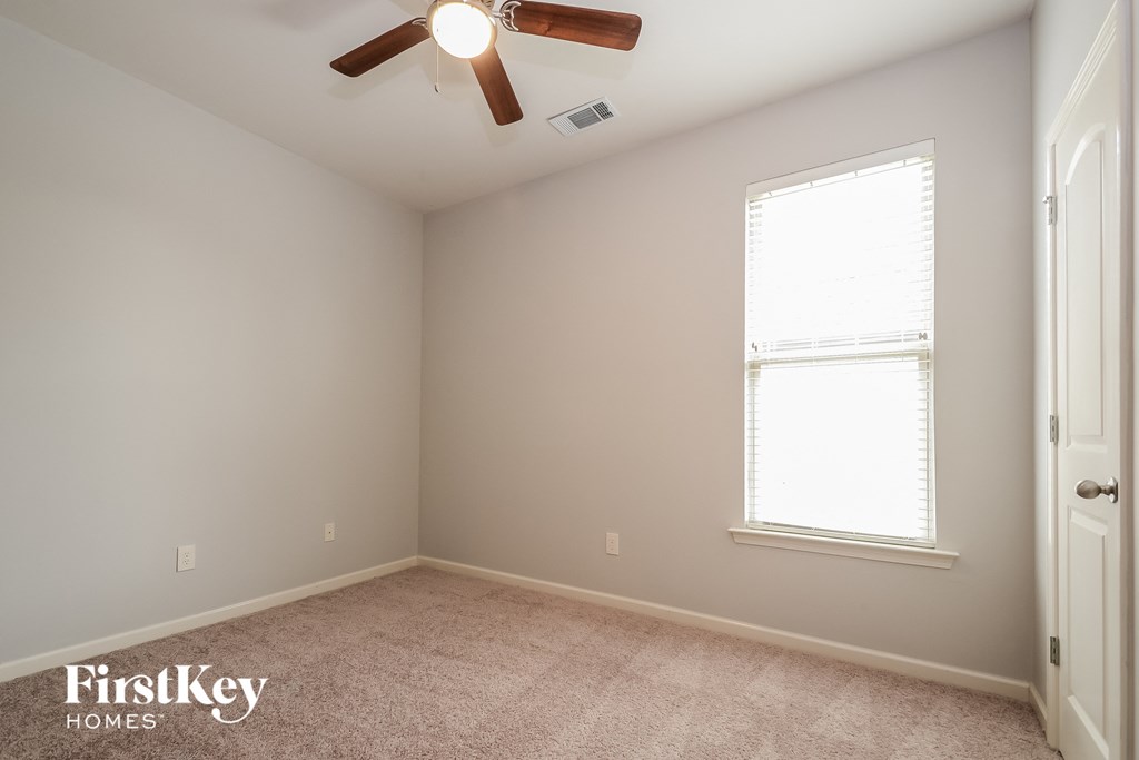 a bedroom with a ceiling fan and a window
