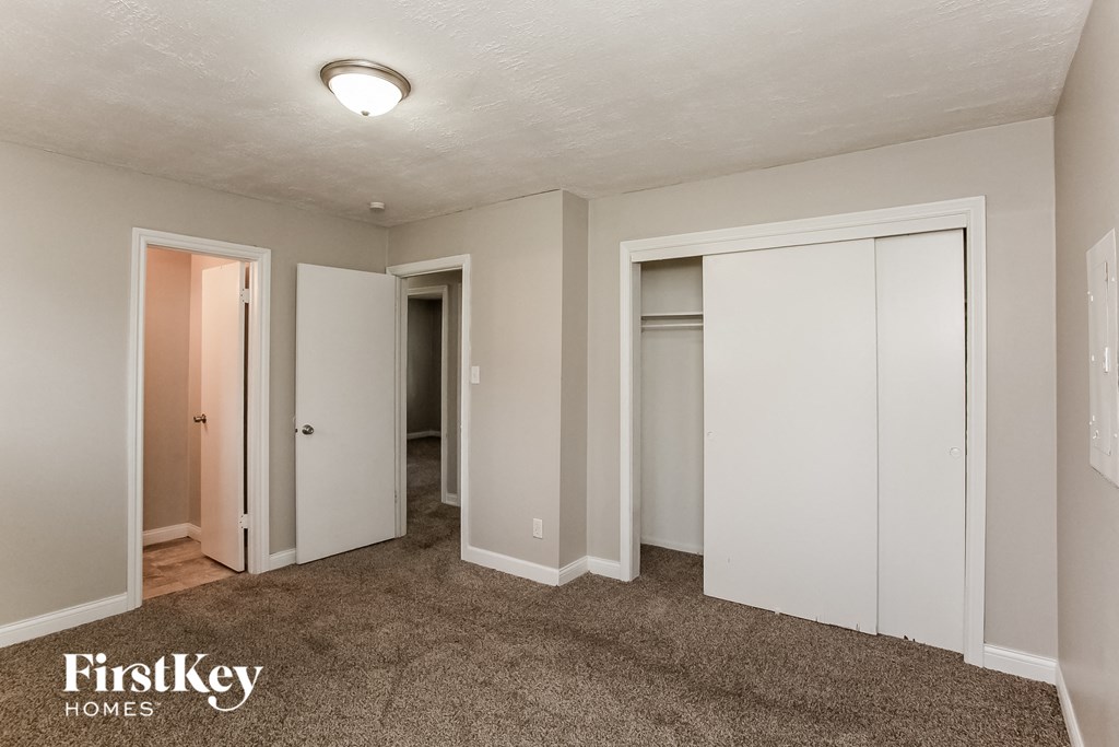 A carpeted room with a FirstKey Homes logo.