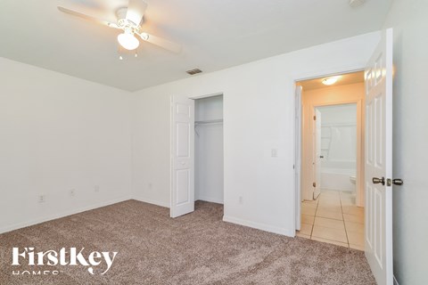 a bedroom with a closet and a ceiling fan