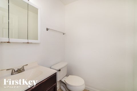 a bathroom with a toilet and a sink and a mirror
