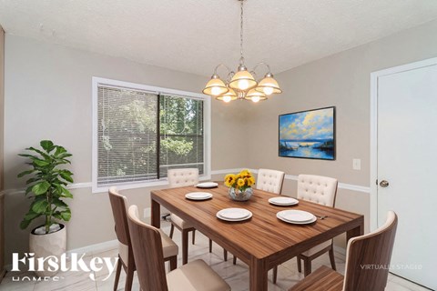 A dining room with a wooden table set for four.