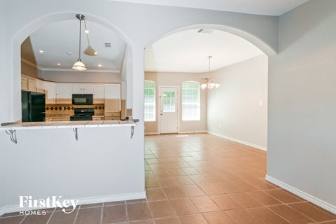 A kitchen with a white counter and a black fridge.