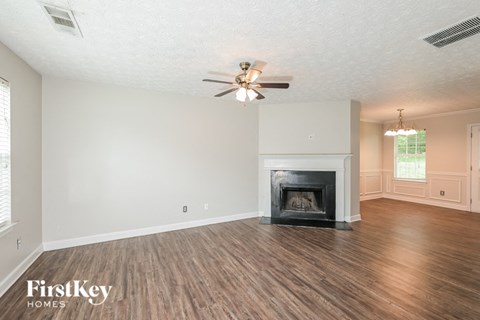 a living room with a fireplace and a ceiling fan