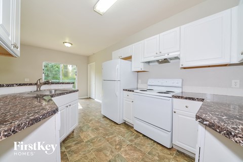 a kitchen with white appliances and granite counter tops