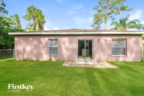 a pink house with a grass yard and a backdoor