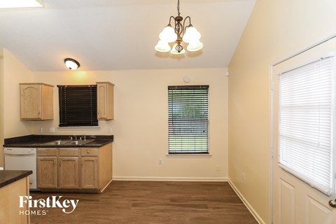 A kitchen with wooden cabinets and a black countertop.