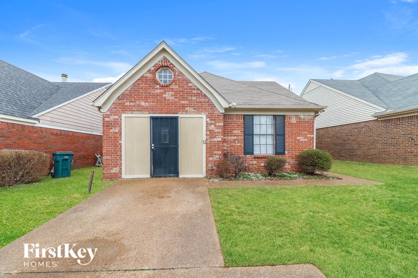A brick house with a garage door is for sale.