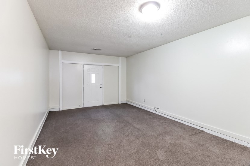 A room with a carpeted floor and a white door.