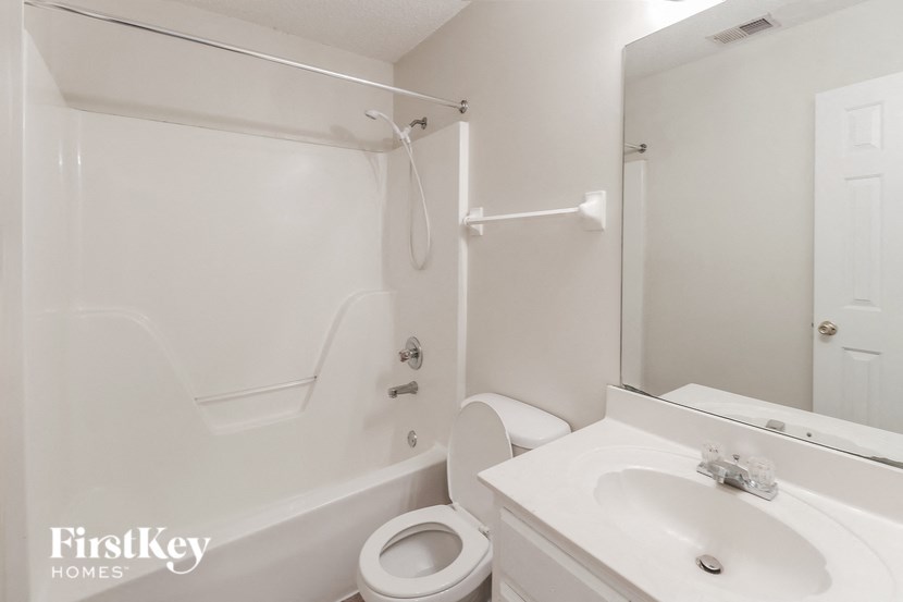 A white bathroom with a toilet, sink, and bathtub.
