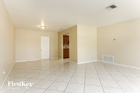A spacious empty room with a doorway leading to another room.