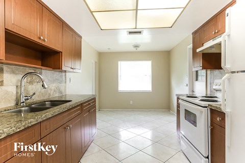 A kitchen with brown cabinets and a white refrigerator.