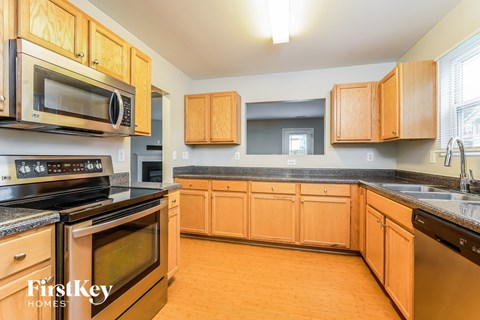 A kitchen with wooden cabinets and black appliances.
