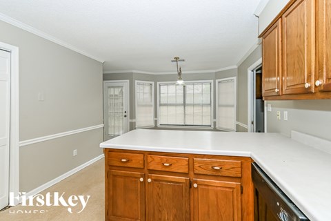 A kitchen with wooden cabinets and a white countertop.