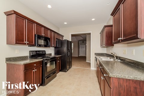 a kitchen with wood cabinets and granite counter tops and black appliances