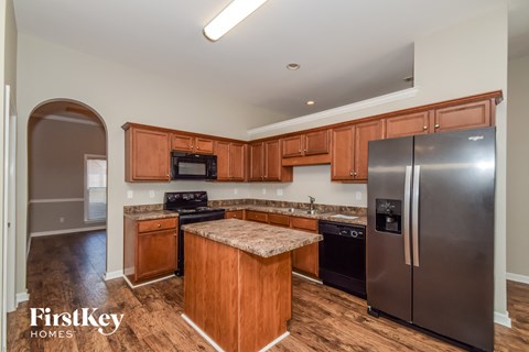 A kitchen with wooden cabinets and a stainless steel refrigerator.