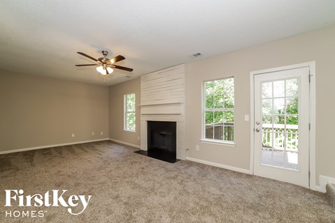 a living room with a fireplace and a ceiling fan