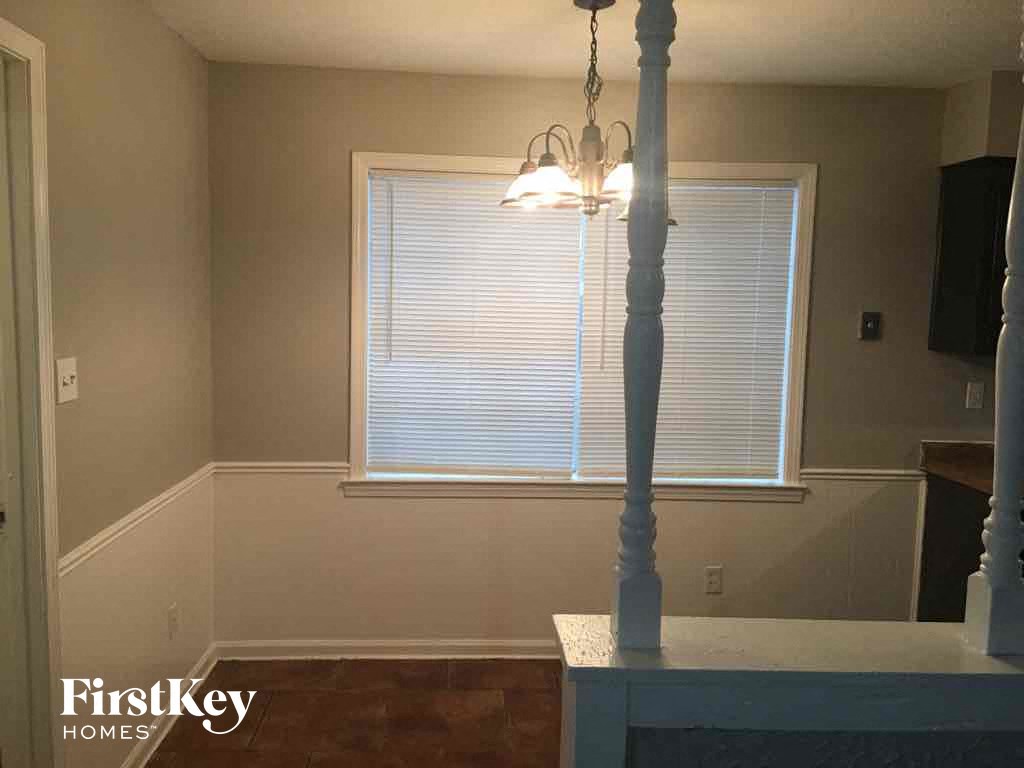 A room with a window and a chandelier.