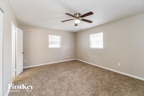 a bedroom with carpet and a ceiling fan