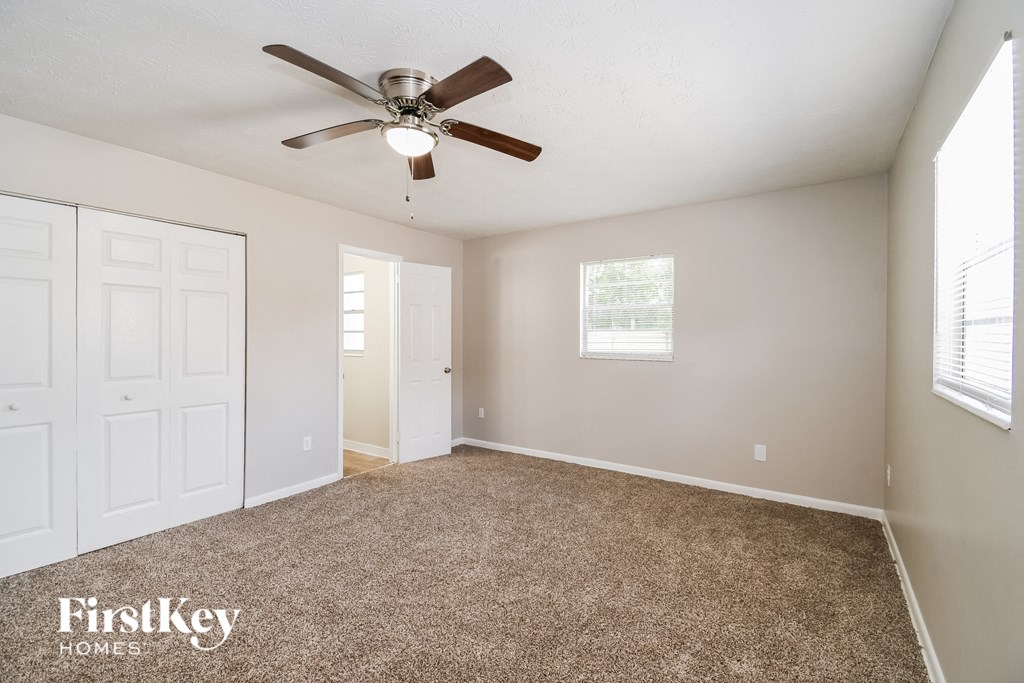 the master bedroom has a ceiling fan and a carpeted floor
