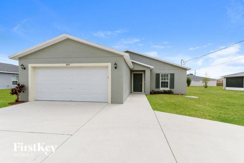 A two-car garage with a white door is the main focus of the image.