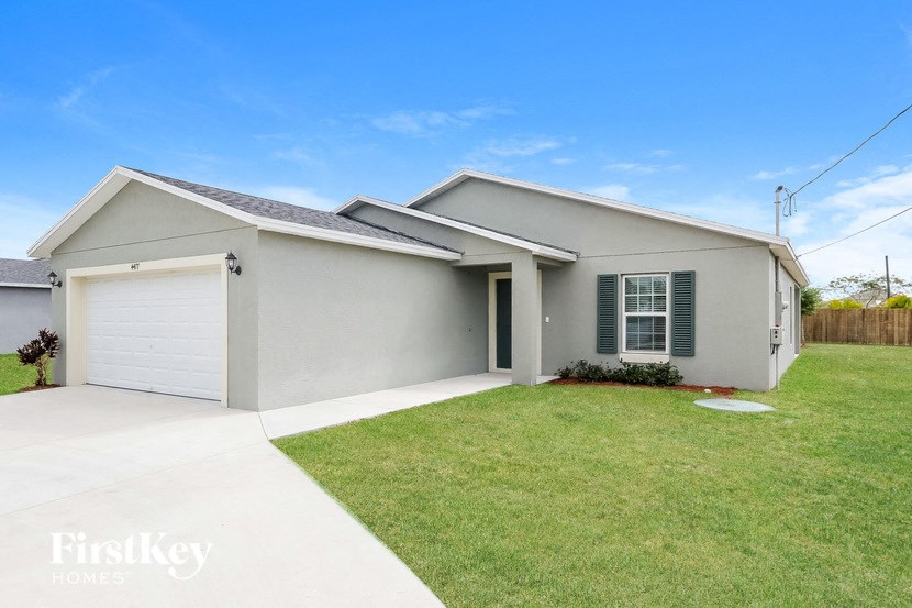A house with a grey roof and a white garage door.