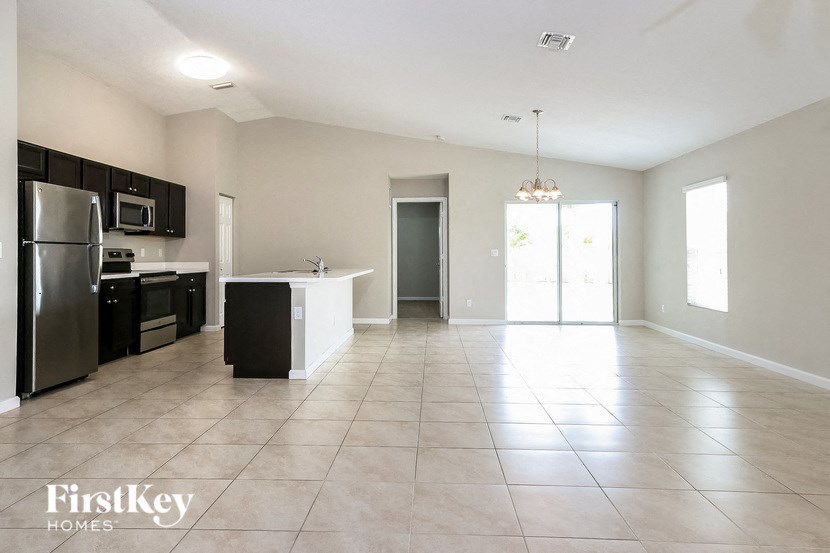 A kitchen with a refrigerator, microwave, and oven.