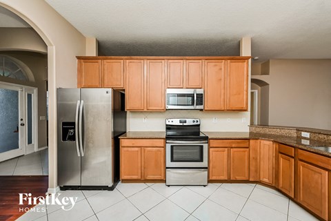A kitchen with wooden cabinets and a stainless steel refrigerator.
