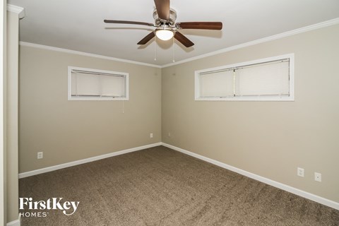 a bedroom with a ceiling fan and a window
