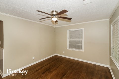 the living room of a home with a ceiling fan and wood floors