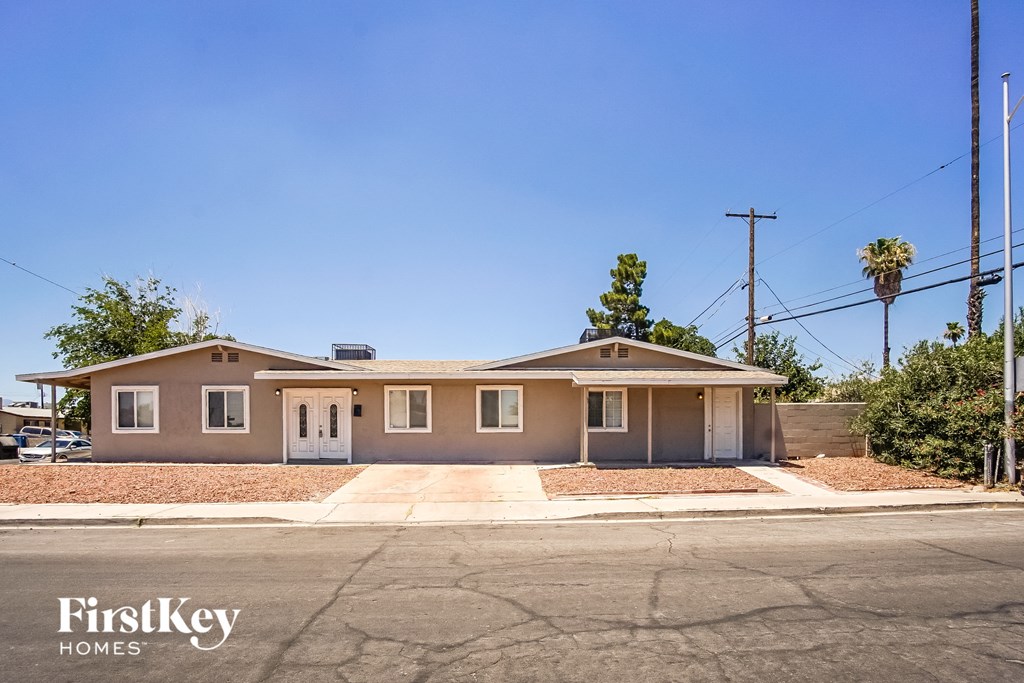 a beige house with a driveway and a street
