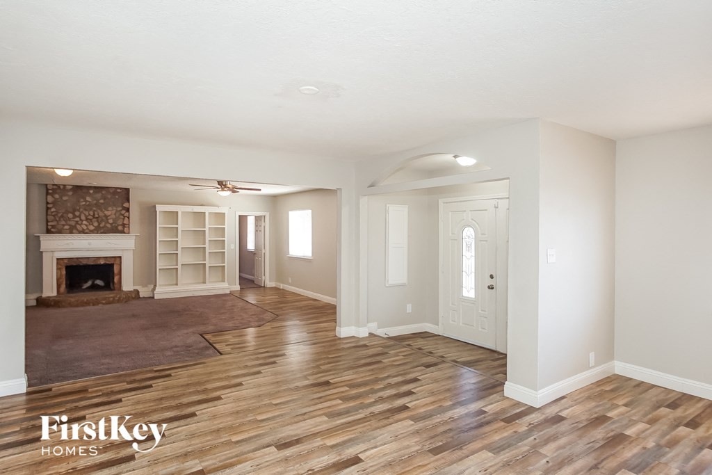 a living room with a fireplace and a wooden floor